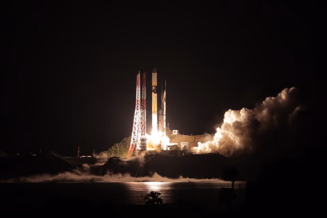 An H-IIA launch vehicle lifting off, the exhaust plume bright against the launch complex.